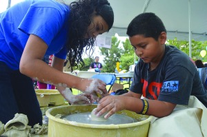 Marisel Maldonado/The Runner Mariela Gallardo, senior, shows Jassiel Meraz, 10, how to work with ceramic clay at the Celebrate CSUB event on April 26. 